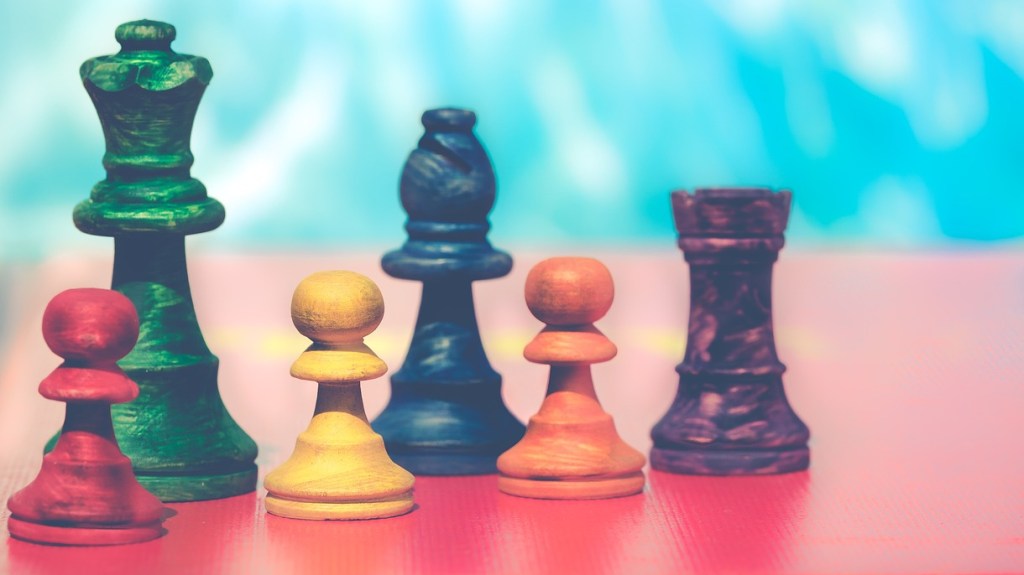 Colorful chess pieces on red surface